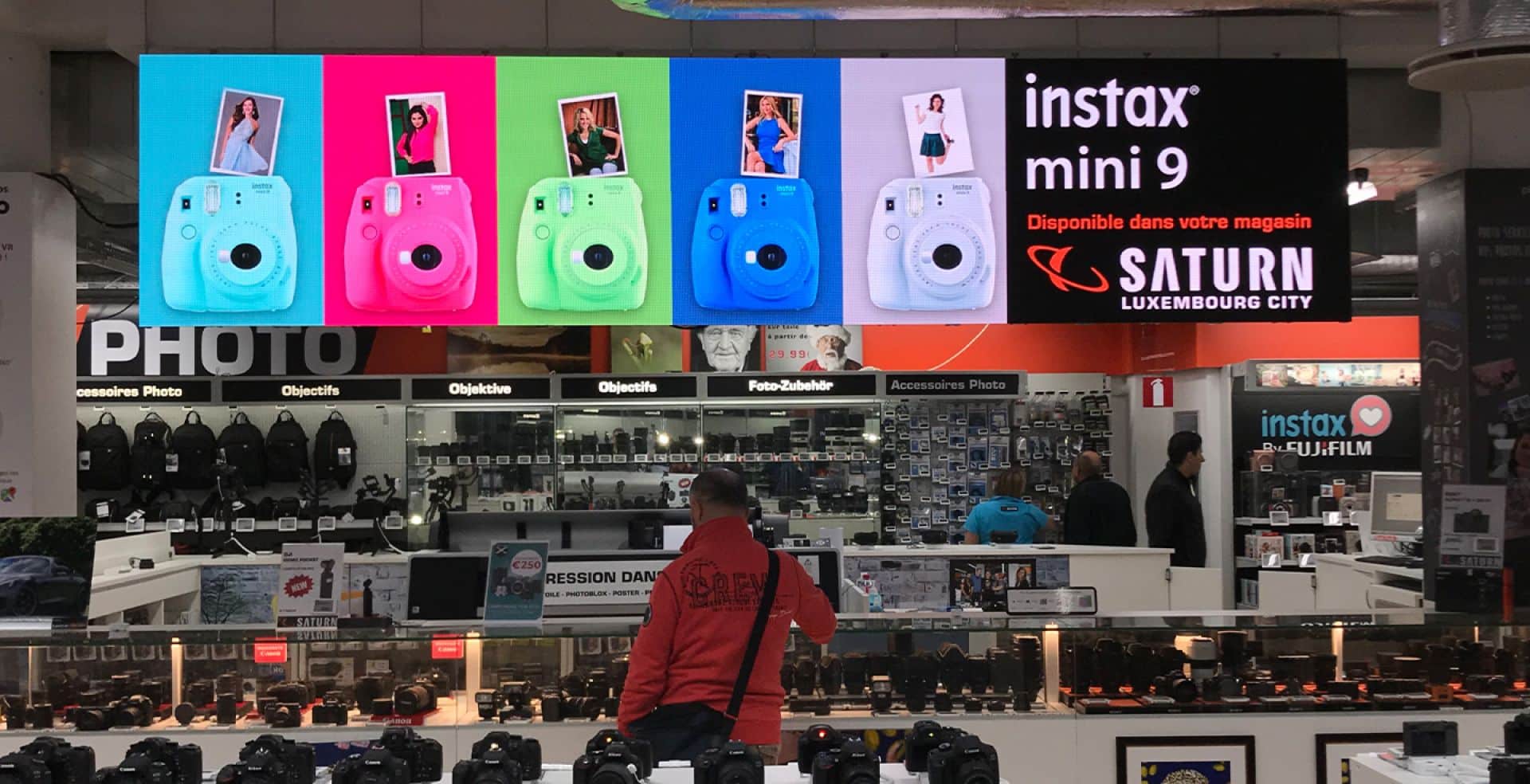 a man standing in front of a display with a camera