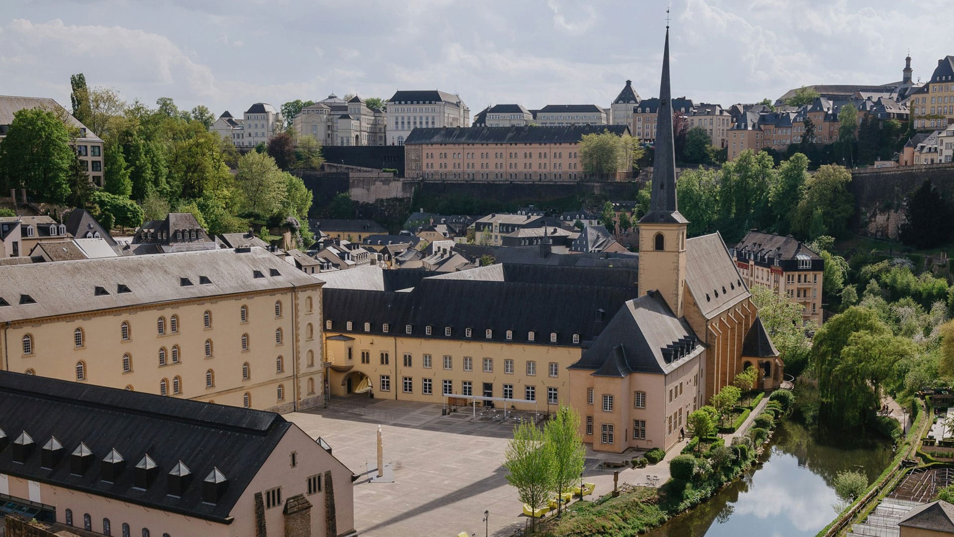 a large building with a steeple and a river in front